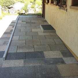 Rampe aus Steinplatten zur Überwindung von Stufen bei der Haus-Eingangstür