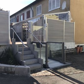 Eine Hebebühne, links daneben eine Treppe von 6 Stufen mit beidseitigen Handläufen