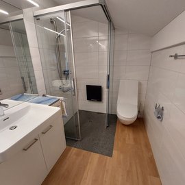 Ein Badezimmer mit einer neu eingebauten bodenebenen Dusche