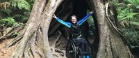 Sonja Häsler est assise en fauteuil roulant dans la cavité du tronc d'un arbre géant