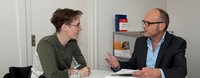 Ein Mann berät eine Frau in Rechtsfragen.