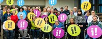 Persone con e senza disabilità che tengono in aria il logo dell'iniziativa di inclusione
