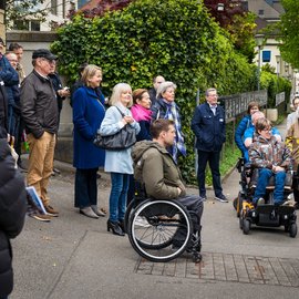 Rollstuhlfahrer und andere Menschen bestaunen etwas	