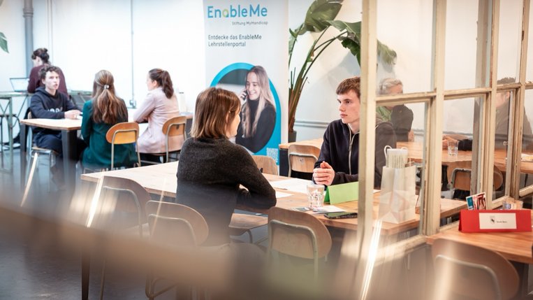 2 Personen diskutieren an einem Tisch