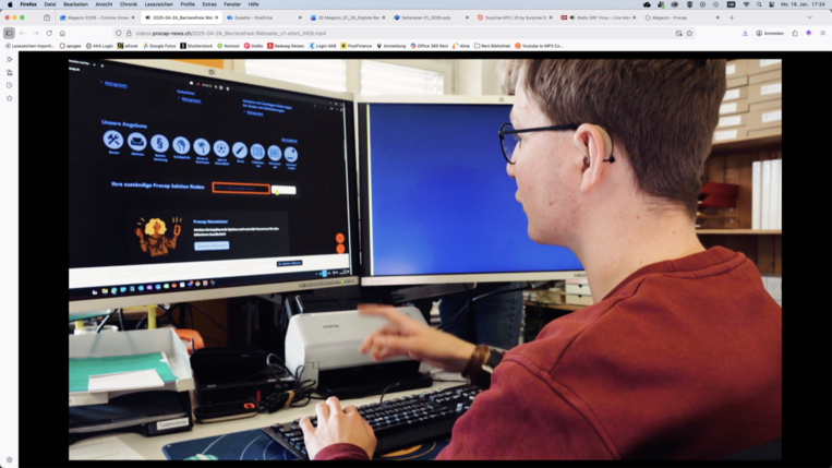 Ein Mensch mit Behinderung sitzt vor einem Computer mit 2 Bildschirmen