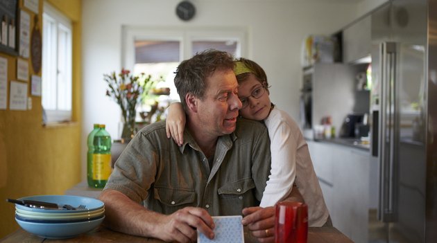 Hanna repose sa tete sur l'épaule de son père.