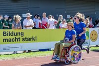 Fussgängerin unterstützt Rollstuhlfahrerin bei 80 Meter Lauf