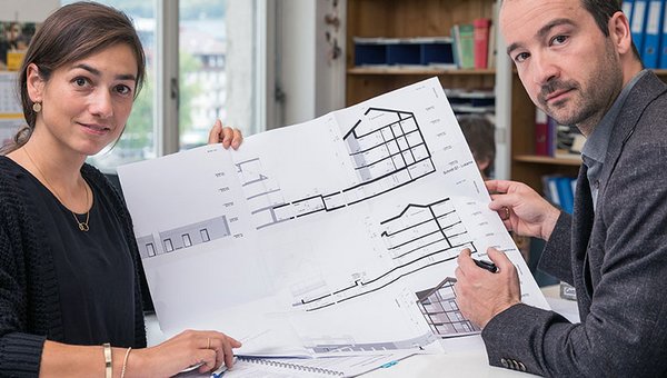 Zwei Bauberater:Innen bei der Arbeit