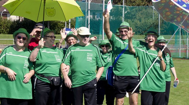 Eine Sportgruppe von Procap winkt lächelnd in die Kamera