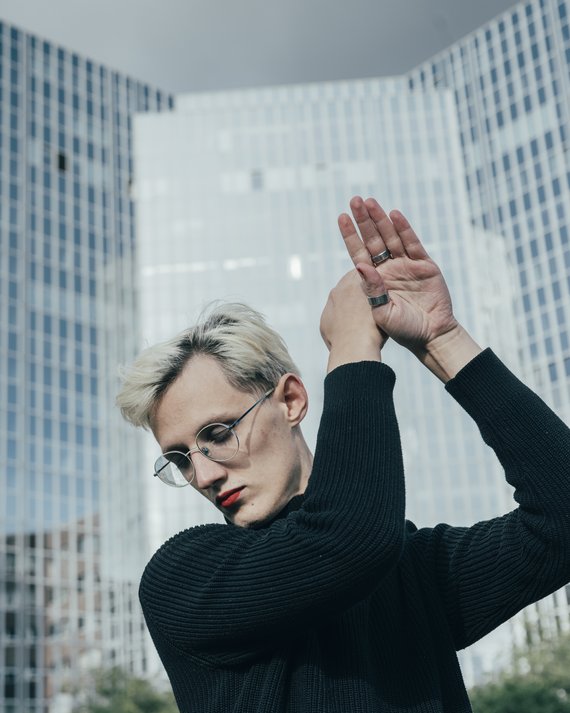 Performer vor Hochhäusern deren Fassaden grösstenteils aus Glas sind.