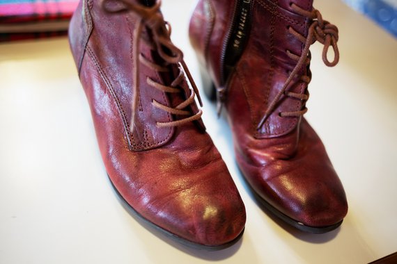 Sur la photo, une paire de bottines à talon en cuir rouge et lacets 