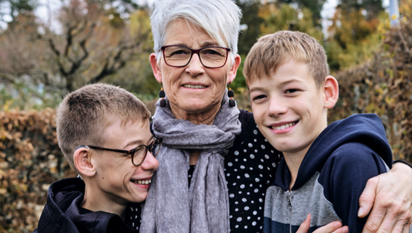 Une grand-mère tient ses deux petits-enfants dans ses bras