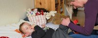 Eine Mutter hilft ihrem Sohn beim Kleider anziehen