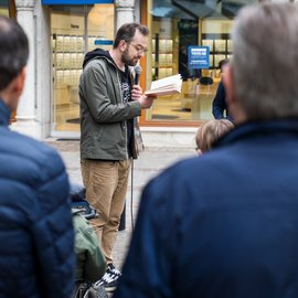 Ein Mann liest stehend aus einem Buch vor